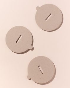 three round objects with holes in the middle on a white surface and one has a hole for an object to be cut out