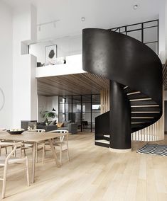 a spiral staircase in the middle of a living room with wooden floors and chairs around it