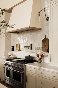 a stove top oven sitting inside of a kitchen next to a pot and pan on a counter