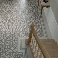 the stairs are decorated with white and beige tile, along with two chairs on either side