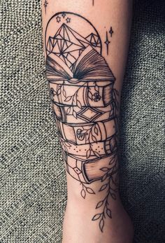 a person with a tattoo on their leg that has books in the shape of a book