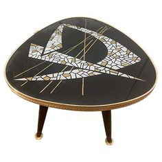 a black and gold table with a design on the top that is shaped like an eye