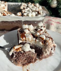 a piece of chocolate cake with marshmallows on top is sitting on a plate