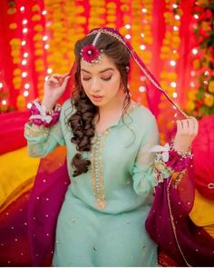 a woman with long hair wearing a blue dress and holding a flower in her hand