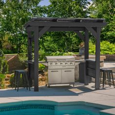 an outdoor kitchen with grill and bar stools next to a swimming pool in a backyard