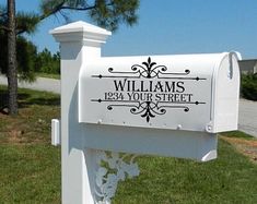 a white mailbox sitting on the side of a road