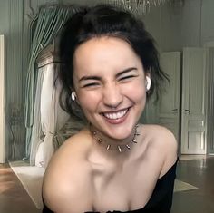 a smiling woman in a black dress sitting down