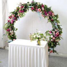 a white table topped with flowers and greenery