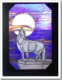 a stained glass window with a wolf on it's side and the moon in the background