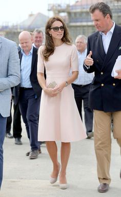 a woman in a pink dress is walking with other people