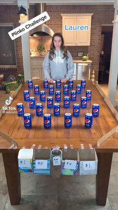 a woman standing in front of a table filled with beer cans