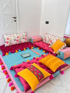 a couch made out of pillows and blankets with pom - poms on it