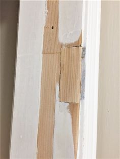 the corner of a door with some paint on it and a piece of wood sticking out