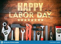 happy labor day written on wooden background with tools