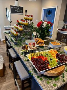 a buffet table filled with lots of different types of food on plates and trays