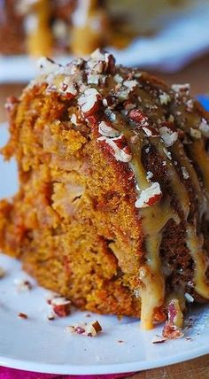 a close up of a piece of cake on a plate with icing and nuts