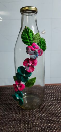 a glass jar filled with flowers on top of a table