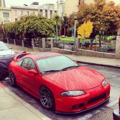 a red sports car is parked on the street