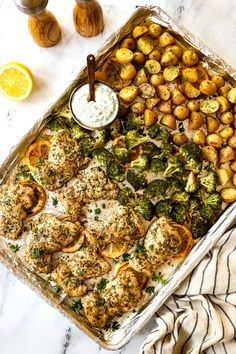 a casserole dish with chicken, broccoli and potatoes on the side