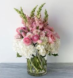 a glass vase filled with pink and white flowers