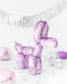 an inflatable balloon dog sitting on the floor next to other balloons and streamers