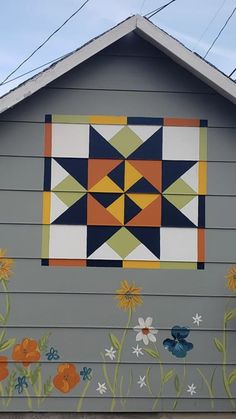 an image of a house with flowers painted on the side and behind it is a sunflower patch