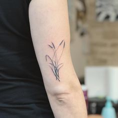 a woman with a tattoo on her arm has a small flower in it's left arm