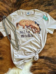 Salty Mama western graphic tee 🐴 Fit: Draped Unisex  Feel: Super soft. Lightweight material, but not sheer. Fabric Content: 95% Polyester / 5% Spandex Care instructions: Machine wash inside out. Gentle Cycle. Cold water. Do not bleach. Tumble dry low. Funny Western Shirts, Western Sublimation, Western Graphic Tees, Sheer Fabric, Western Shirts, Womens Clothing Tops, Tumble Dryer, Cold Water, Graphic Tee