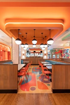 the inside of a restaurant with colorful flooring and wooden booths on either side of the counter