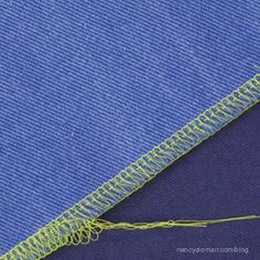 a blue piece of fabric with yellow stitching on the side and an orange thread at the end