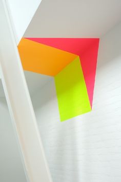 a room with white walls and bright colored paper hanging from the ceiling over it's doorway