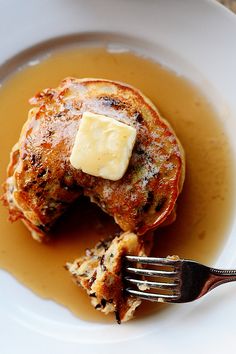 a white plate topped with pancakes covered in butter