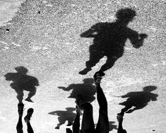 several people are standing in the water with their shadows