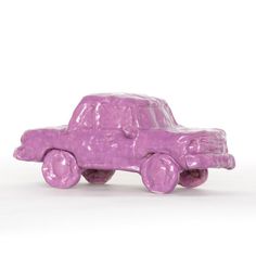 a purple toy car sitting on top of a white surface