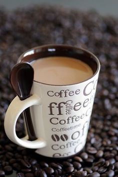 a coffee cup sitting on top of a pile of coffee beans