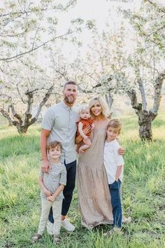 a family posing for a photo in an apple orchard