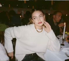 a woman sitting at a table with candles in the background