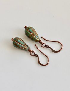 "boho earrings small dangle earrings turquoise glass earrings These beads are small teardrop, melon shaped Czech glass. They are turquoise with a metallic copper coating, which highlights the grooves in the beads. They dangle from small, antiqued copper plated brass hook ear wires. Length of earrings from top of ear wires is only 1 1/4\". Glass bead measures 13mm, 1/2\". You can enter my shop here: gypsydangles.etsy.com" Turquoise Teardrop Czech Glass Earrings, Small Dangle Earrings, Brass Hook, Small Boho, Metallic Copper, Earrings Turquoise, Turquoise Glass, Leverback Earrings, Turquoise Green