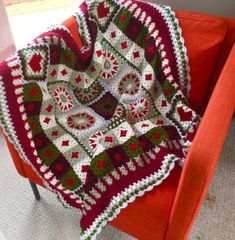 a crocheted afghan is sitting on an orange chair