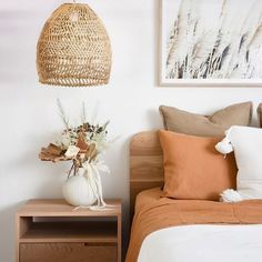 a bedroom with a bed, nightstand and basket hanging from the wall above it's headboard