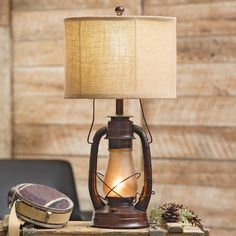 a lamp sitting on top of a wooden table next to a bag and other items