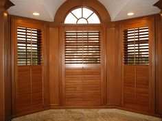 an arched window with wooden shutters and marble flooring in front of the windows