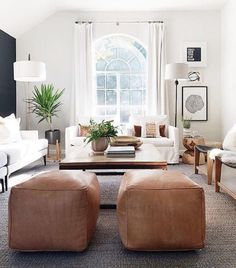 a living room with couches, chairs and tables in front of a large window