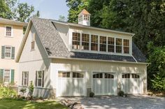 a two car garage with an attached porch and windows on the top floor is shown