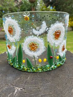 a glass bowl sitting on top of a tree stump covered in beads and flowers with bees