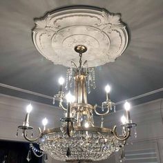 a chandelier hanging from the ceiling in a room with white walls and ceilings