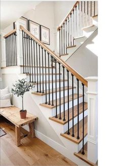 a living room filled with furniture and a stair case next to a wooden table on top of a hard wood floor