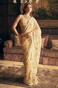 Cream gold net saree features embroidery in mirror work, crystal and sequin in an intricate paisley pattern. Comes with an embroidered strappy padded blouse and a petticoat. - Aza Fashions Gold Net Saree, Cream Mirror, Strappy Blouse, Sequin Lehenga, Seema Gujral, Mirror Work Saree, Mirror Work Lehenga, Floral Saree, Net Saree