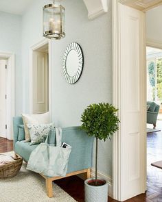 a living room with blue couches and pillows on the floor in front of a mirror