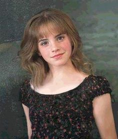 a young woman in a black dress posing for the camera with her hand on her hip